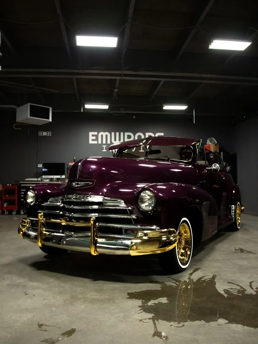 Purple classic Chevrolet bomb with chrome and gold wire wheels in the EMWRAPS shop
