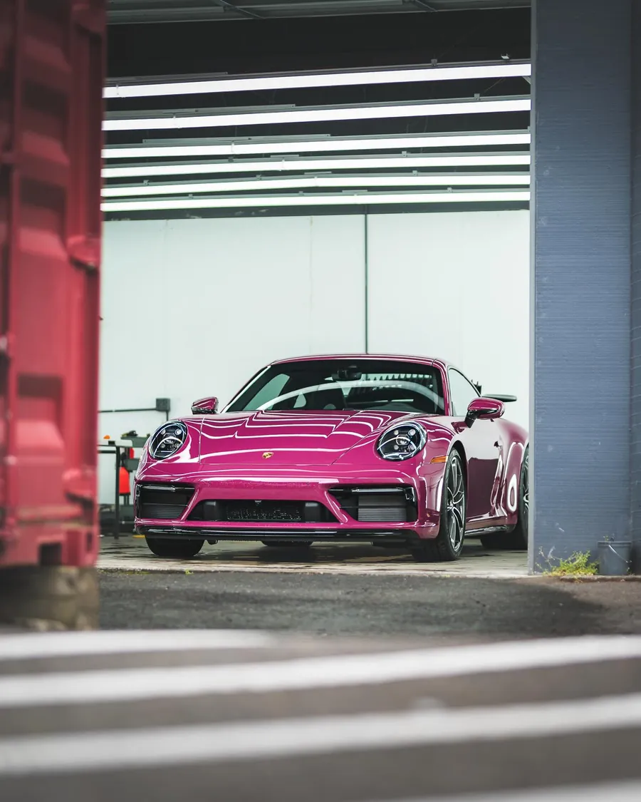 Ruby Star Porsche 911 with full body PPF in the EMWRAPS bay doorway