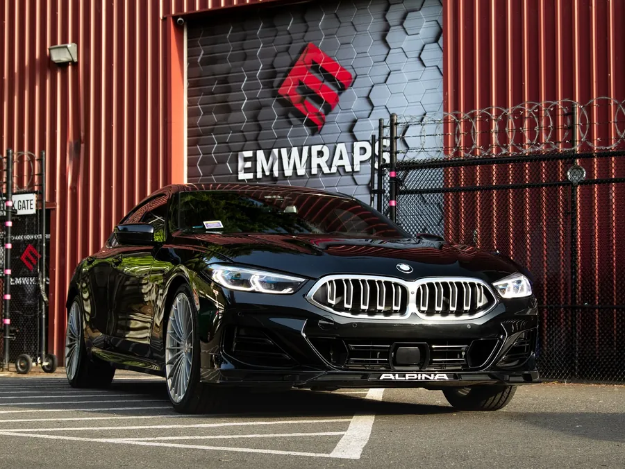 Black Alpina B8 Gran Coupe with full body gloss PPF in front of the EMWRAPS door