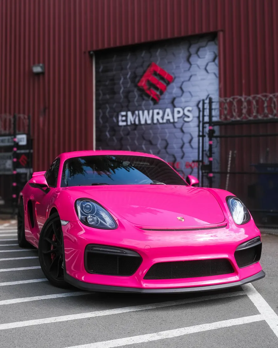 Porsche Cayman in hot pink color PPF in front of the EMWRAPS door