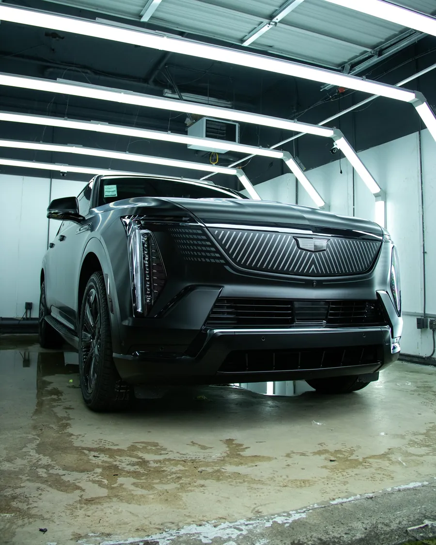 Black Cadillac Escalade IQ in full stealth PPF in the EMWRAPS install bay