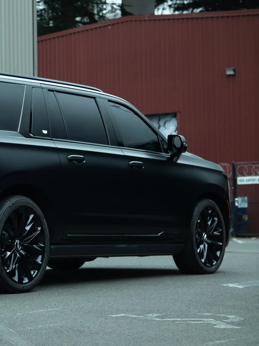 Black Cadillac Escalade in full body stealth PPF, rear three-quarter view