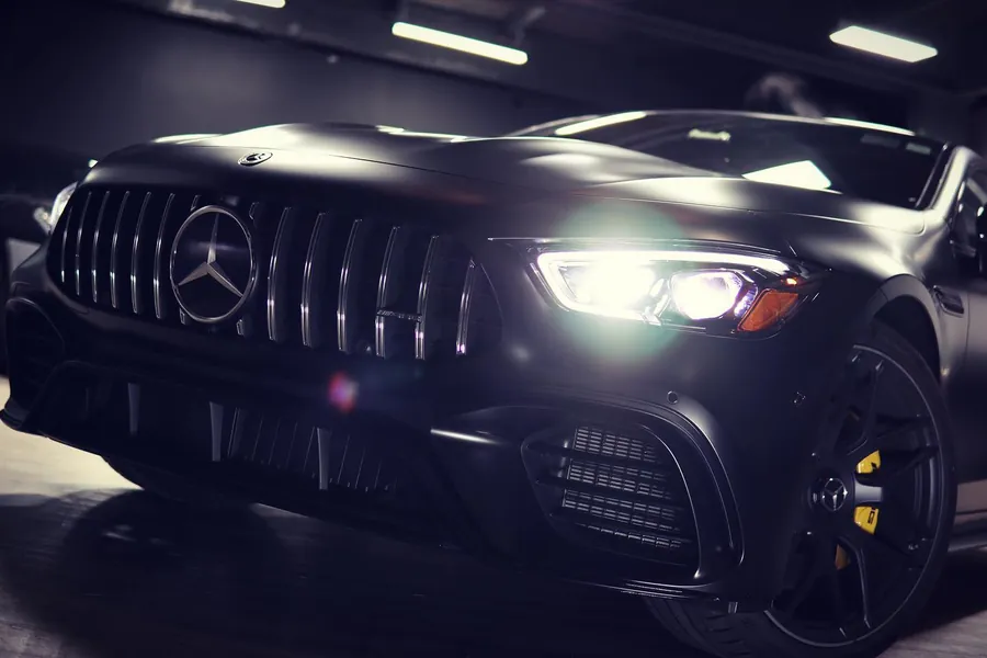 Black Mercedes-AMG GT 63 S four-door in stealth PPF, front three-quarter at night