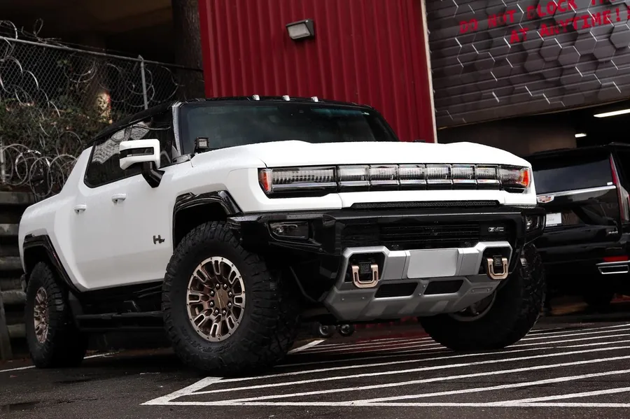 White GMC Hummer EV pickup in matte PPF outside the EMWRAPS shop