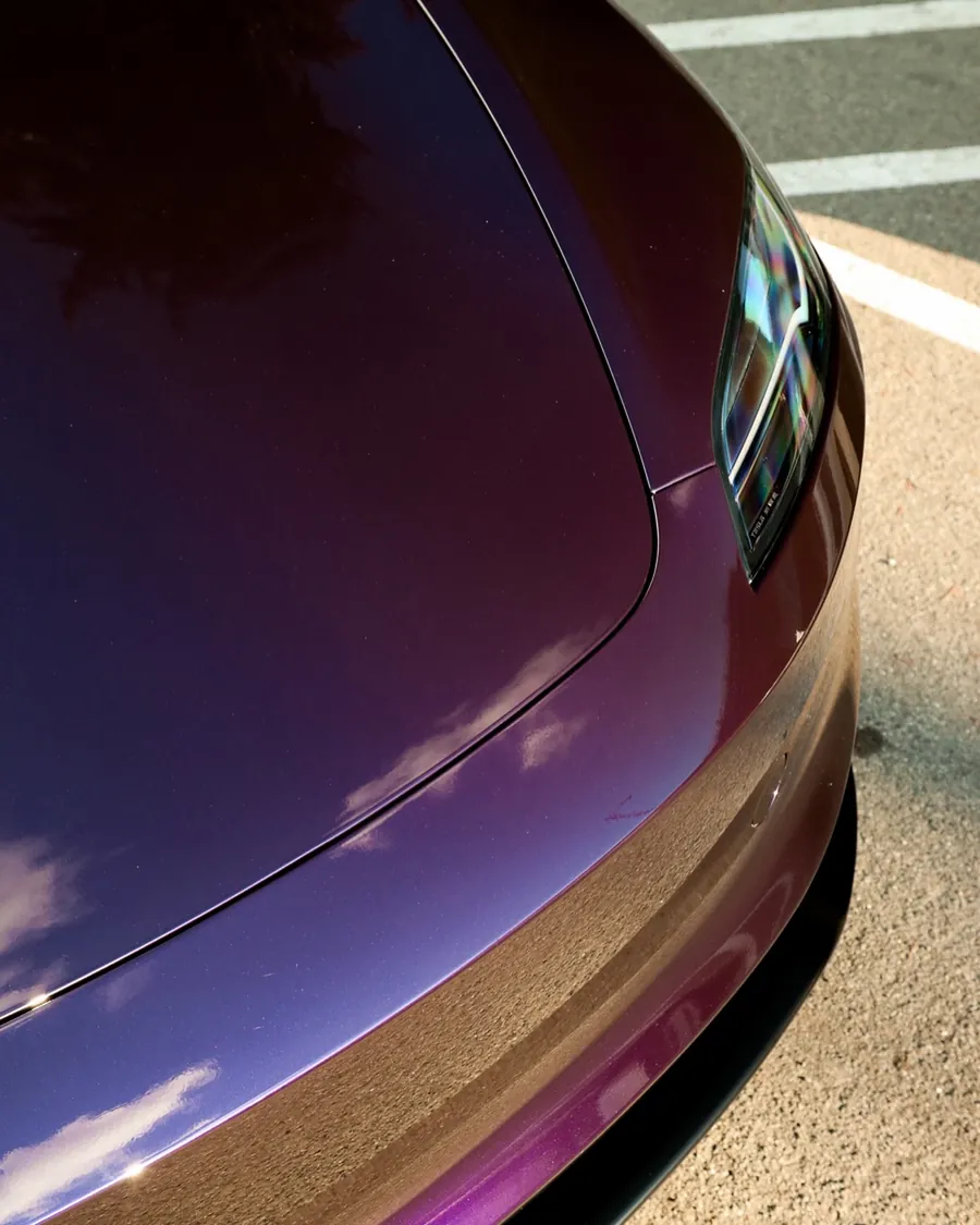 Hood and headlight of a Tesla Model 3 in Midnight Purple gloss color PPF