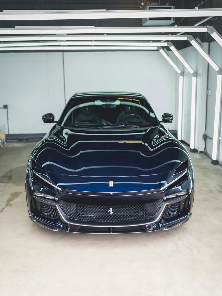 Dark blue Ferrari Purosangue with full body clear PPF in the EMWRAPS install bay