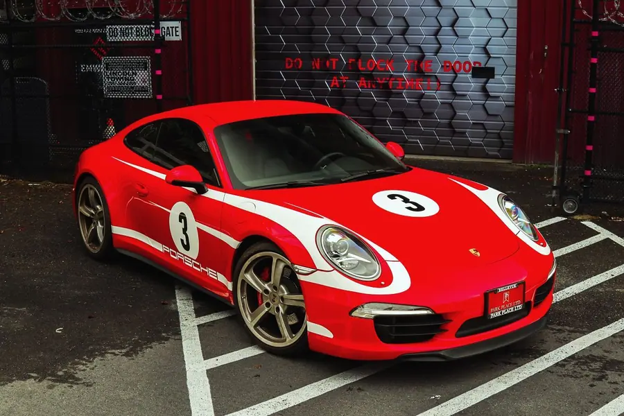 Porsche 911 in a red and white heritage livery with race number 3