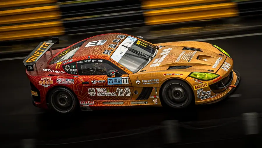 Race cars in custom liveries at speed at the Macau Grand Prix